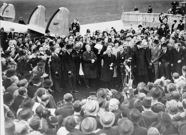 Neville Chamberlain showing the Anglo-German Declaration (the resolution) to commit to peaceful methods signed by both Hitler and himself, at Heston Aerodrome, on his return from Munich on 30 September 1938