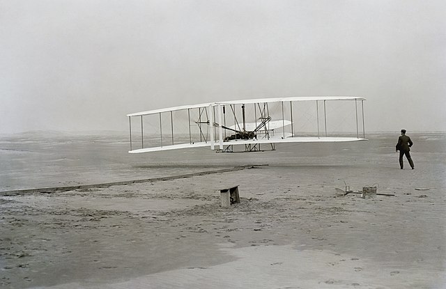 Orville Wright making the first powered flight.